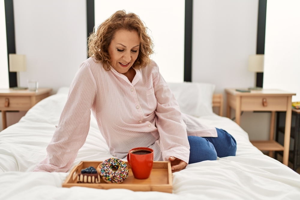 Middle,Age,Caucasian,Woman,Having,Breakfast,Sitting,On,The,Bed